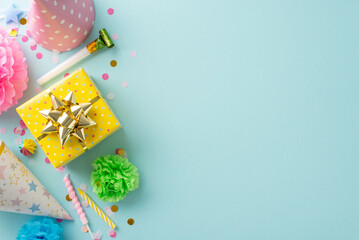 Festal gathering visualization. Top view shot capturing festive elements like candies, wrapped gift, birthday hats, party blower, candles, confetti on subtle sky blue background with space for text