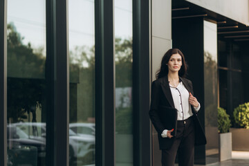 business woman in a suit standing near an office building