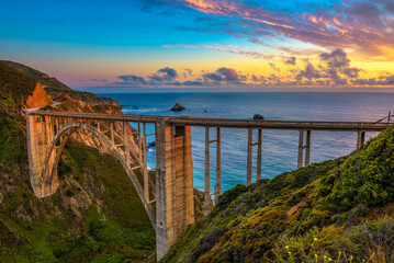 Bixby Bridge also known as Rocky Creek Bridge and Pacific Coast Highway at sunset near Big Sur in California, USA. - obrazy, fototapety, plakaty