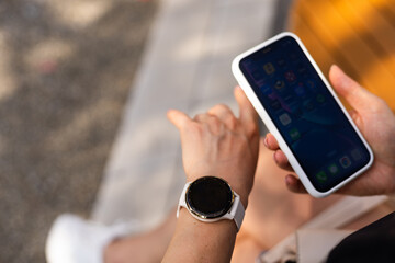 phone in the hands of a girl and a smart watch on her hand mockup