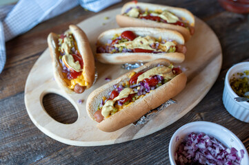 Hot Dogs with cheese, onions, pickles, mustard and ketchup. Delicious Party Food or homemade Fast Food
