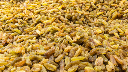 Yellow raisins, top view. Background of white grape raisins, dry raisin on the pile