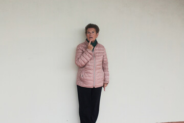 older woman leaning on the wall thinking