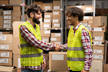 Warehouse worker doing handshake in workplace. Partnership agreement after negotiations for...