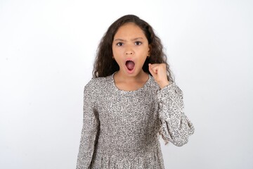 beautiful caucasian teen girl wearing flowered dress angry and mad raising fist frustrated and furious while shouting with anger. Rage and aggressive concept. - Powered by Adobe