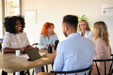 Happy multiracial business people having discussion during meeting at office.