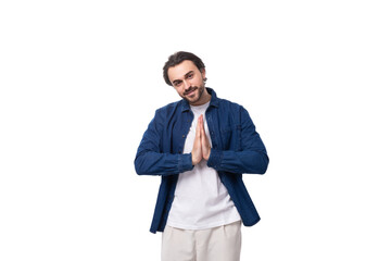 handsome young brunette man in a denim shirt gesturing with his hands on a white background