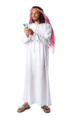 Young Arab man in traditional dress thobe using smartphone at white background