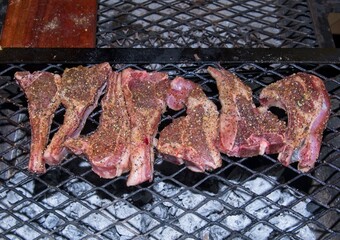 Spiced lamb chops on grid with charcoal fire