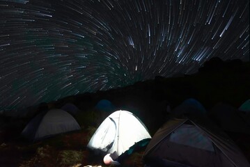 Tents at camp under starry sky at night. Astrophotography
