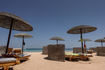 deep blue sky at the beach on vacation in egypt with sunbeds and sun umbrellas