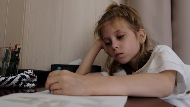 A 9-year-old girl draws with her left hand.
