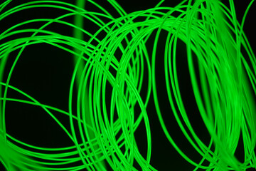 Bright and unusual photos of thin glowing wires, lime, yellow, green burning wire in the dark.