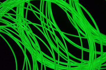 Bright and unusual photos of thin glowing wires, lime, yellow, green burning wire in the dark.