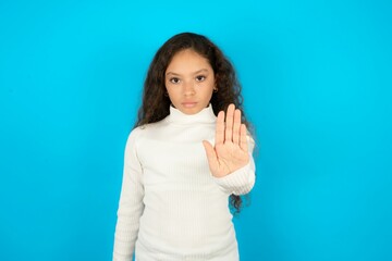 Young beautiful teen girl shows stop sign prohibition symbol keeps palm forward to camera with...
