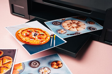 Modern laser printer printing color photos of food close up