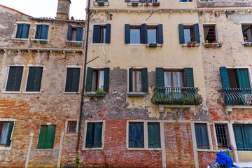 Old town of City of Venice with weathered facades on a wire on a blue cloudy summer day. Photo taken August 6th, 2023, Venice, Italy.