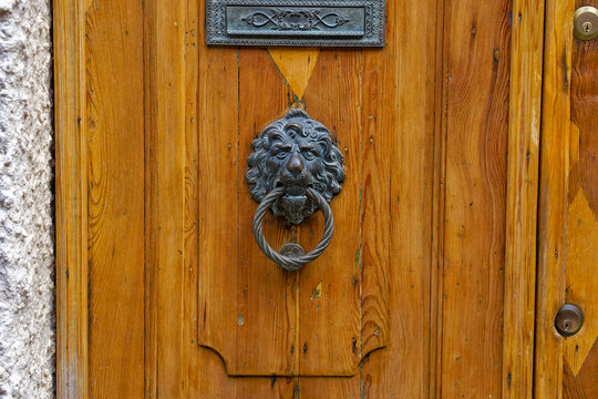 Close-up of beautiful bronze lion head knocker with letter box at wooden door at City of Venice on a summer day. Photo taken August 6th, 2023, Venice, Italy.