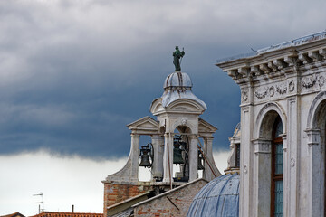 Idyllic view of the old town of Italian City of Venice with bells of catholic church church San Giacomo Apostolo on a cloudy summer day. Photo taken August 6th, 2023, Venice, Italy.