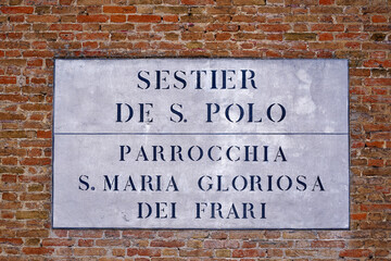 Close-up of white table at brick wall outside of church named Santa Maria Gloriosa dei Frari at the...
