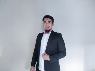 Asian businessman clenches his fist showing excitement while looking at the cell phone he is holding