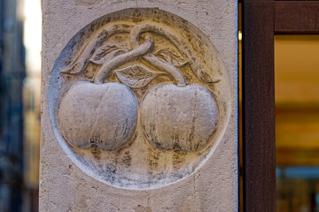 Stone facade with two apples engraved at Italian City of Venice on a sunny summer day. Photo taken August 6th, 2023, Venice, Italy.