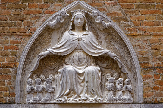 Close-up of brick wall with Madonna della Misericordia and twelve apostles of church San Tomà at the old town of Venice on a sunny summer day. Photo taken August 6th, 2023, Venice, Italy.