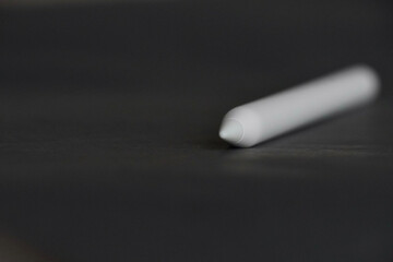 Close-up view of stylus on black background.
