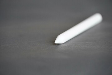 Close-up view of stylus on grey background.
