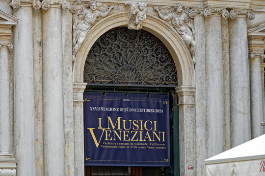 Close-up of entrance of church San Salvador with gate and banner with text I Musici Veneziani on a sunny summer day. Photo taken August 6th, 2023, Venice, Italy.