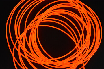 Unusual glowing background of chaotically stacked thin light wires, red glowing tourniquet,...