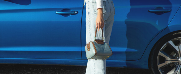 Woman with handbag near the car.