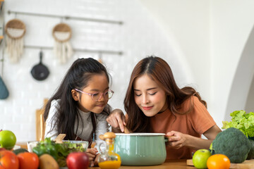 Portrait of happy love asian family mother with little asian girl daughter child help cooking food...