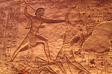 Intérieur du Temple Abou Simbel , Egypte : bas relief de Ramsès II tuant un ennemi - obrazy, fototapety, plakaty