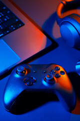 Headphones, joystick and computer keyboard on black table