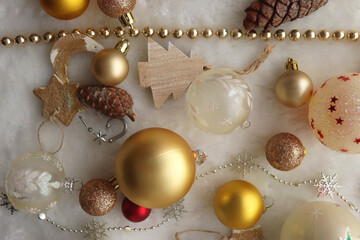 Various colorful Christmas oranments and white faux fur blanket. Top view.