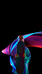 Teen boy standing with skateboard against black background in neon lights with colorful abstract...