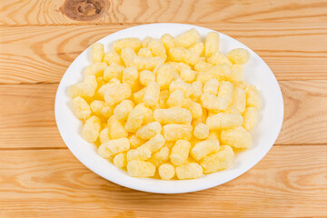 Sweet corn puffs on a white plate on rustic table