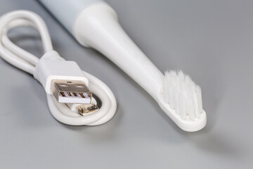 Electric ultrasonic rechargeable toothbrush and charging cable, fragment close-up