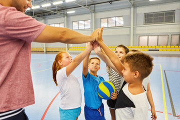 Students and teacher giving high five during gym class