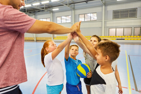 Students and teacher giving high five during gym class
