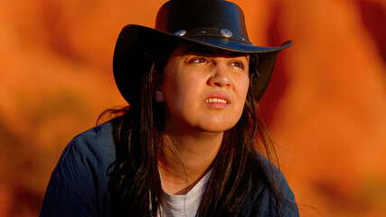 Cowgirl relaxing on a red rock in the desert of Arizona - travel photography