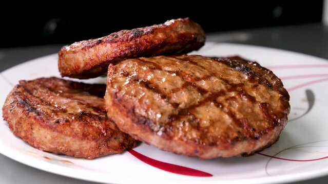 Cooking burgers on a hot grill with a flame Beef cutlets cooked on a barbecue grill.Cooking beef and pork patty for party.