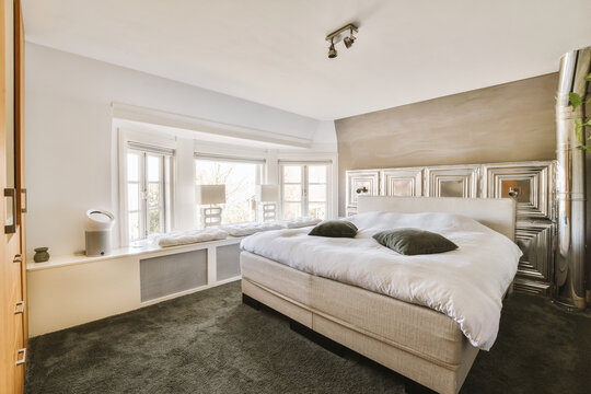 Bedroom with white bed and bright window