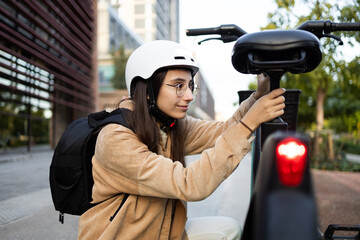 Young commuter locks her bike in the city