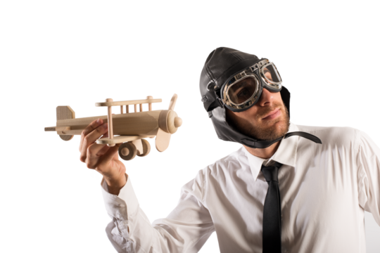 Businessman playing with a wooden aircraft. Concept of startup of a new company - Powered by Adobe