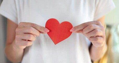 Woman holding red heart made of paper closeup. Charity volunteering and helping those in need