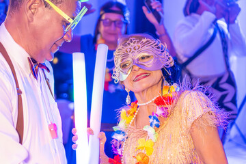 Festive Masquerade Ball Attendees with Glow Sticks