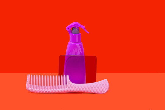 Vibrant cleaning spray and comb on a red background