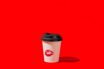 Disposable coffee cup with lipstick mark on red background